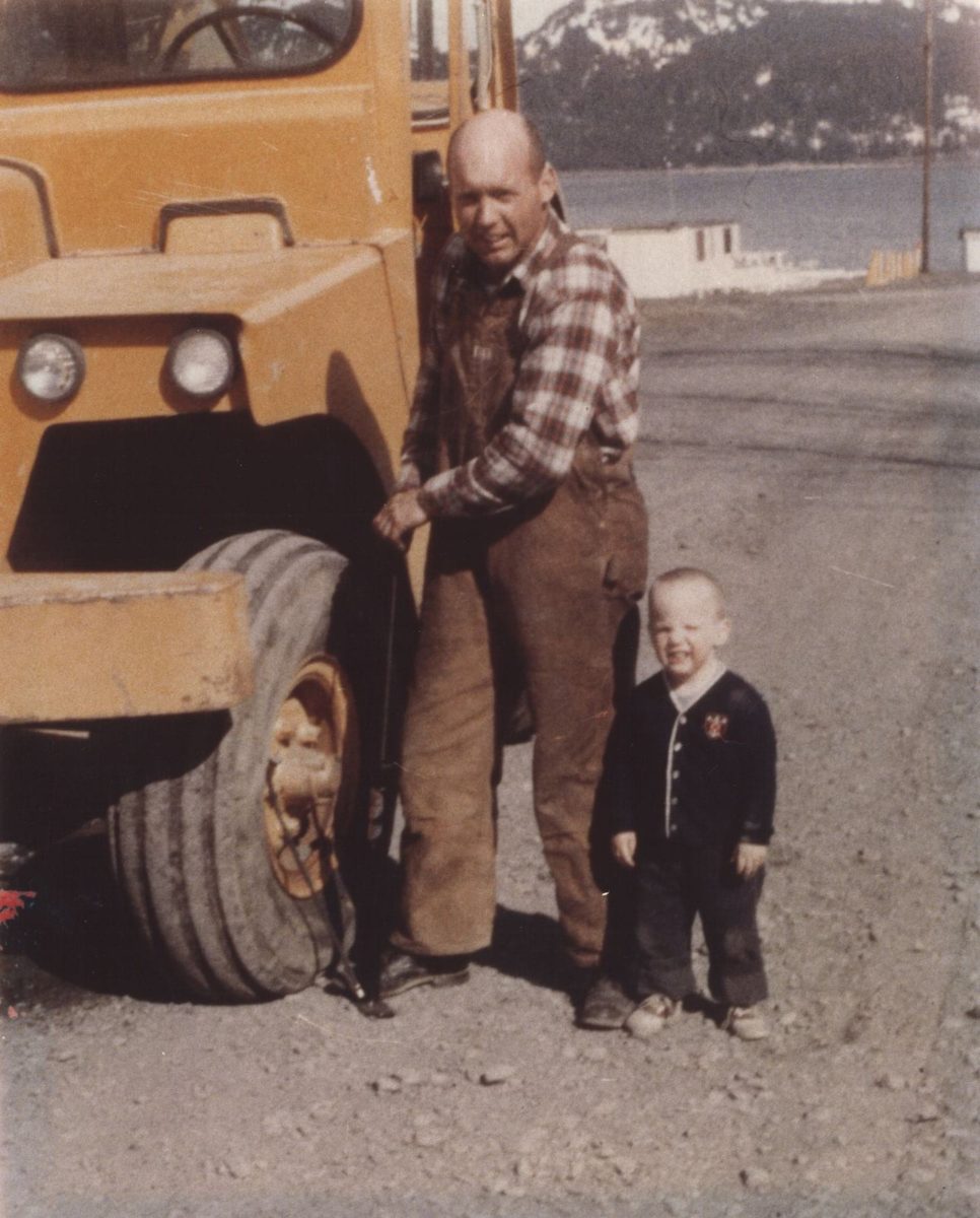 Old photo of father and son next to a vehicle