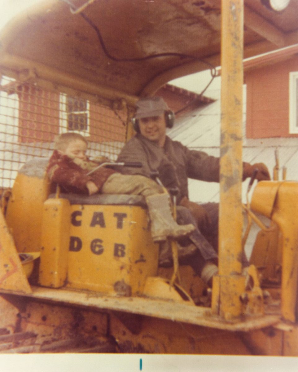 Old photo of father and son operating a dozer